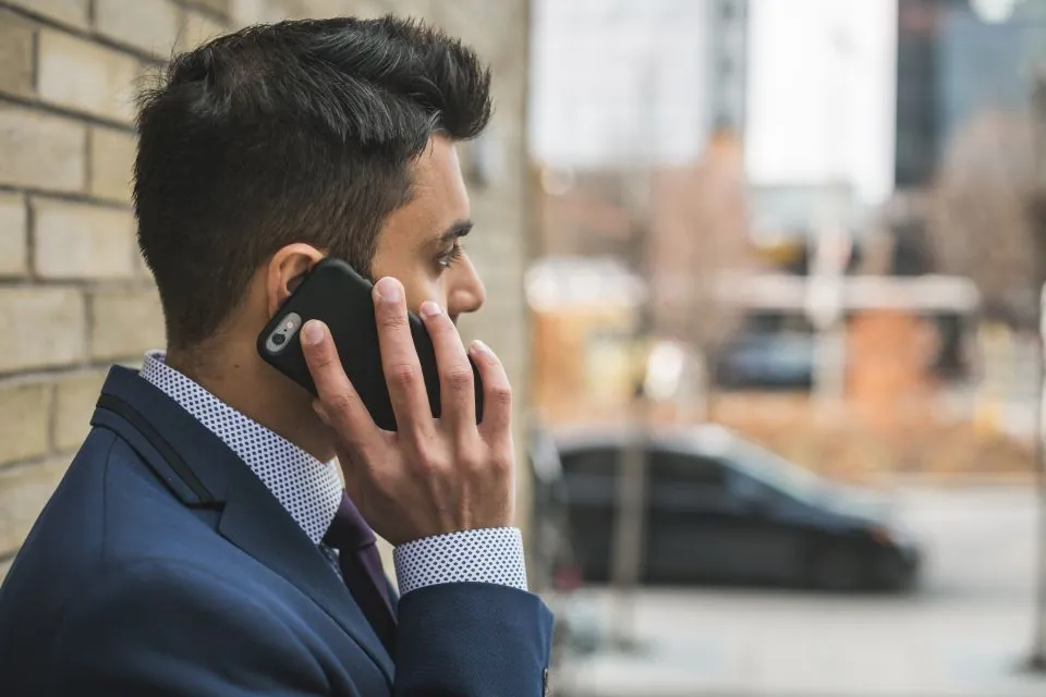 Professionnel au téléphone devant ses bureaux